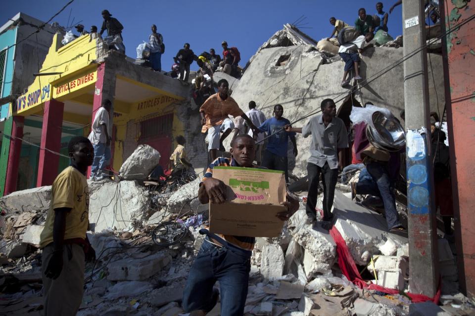 A man runs off with a box of goods in downtown Port-au-Prince.