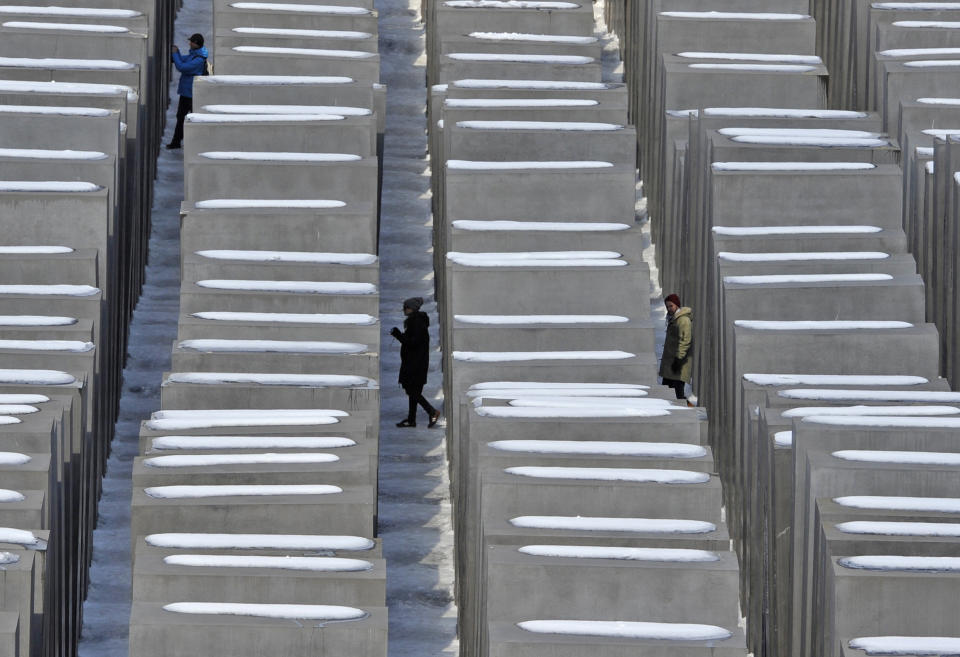 Persons walk through the holocaust memorial in Berlin, on a sunny but cold Monday March 25, 2013. (AP Photo/dpa, Markus Heine)