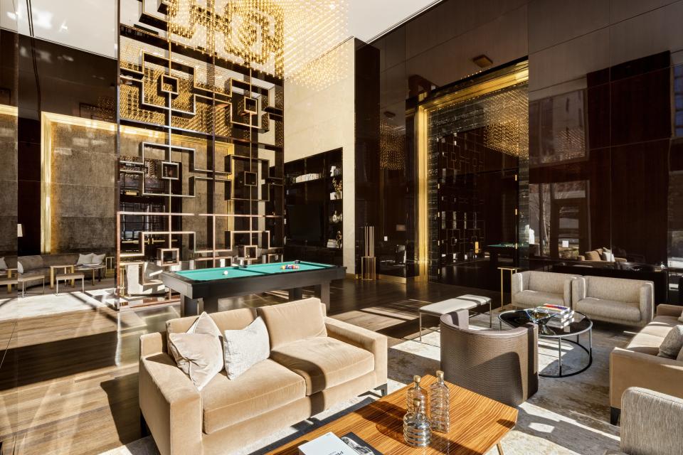 a pool table and chairs in a sunlit seating area on the 14th floor of luxury skyscraper Central Park Tower