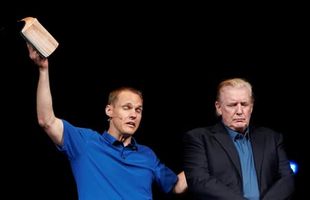 FILE PHOTO: U.S. President Donald Trump stands on stage as Pastor David Platt prays for him at the McLean Bible Church, in Vienna