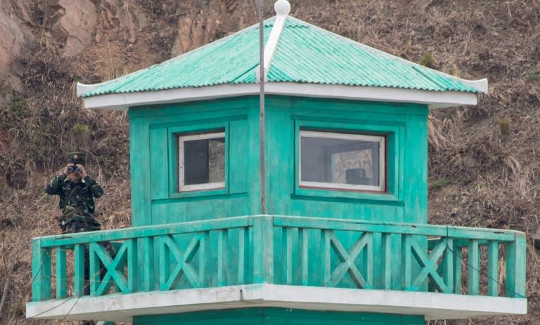 A North Korean looks from a watchtower opposite the Chinese border city of Dandong on April 16, 2017. Despite tensions over the North's missile and nuclear programmes, the atmosphere is more relaxed along the Yalu river that borders China