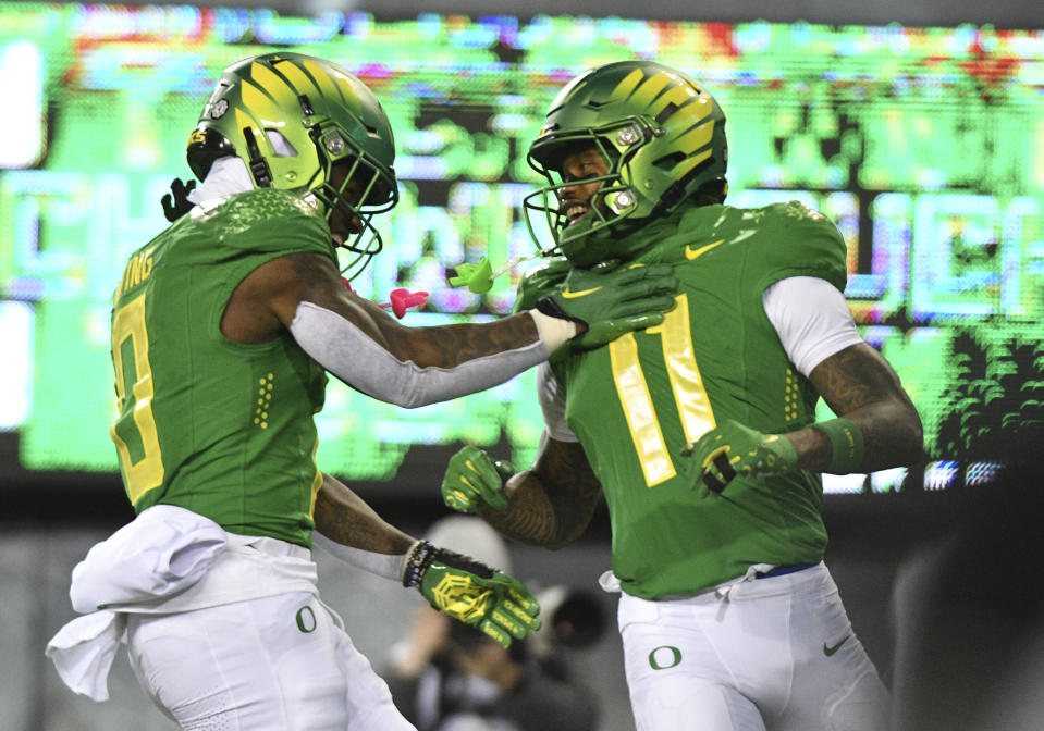 Oregon running back Bucky Irving (0) celebrates wide receiver Troy Franklin's (11) first-half touchdown against Oregon State in an NCAA college football game Friday, Nov. 24, 2023, in Eugene, Ore. (AP Photo/Mark Ylen)