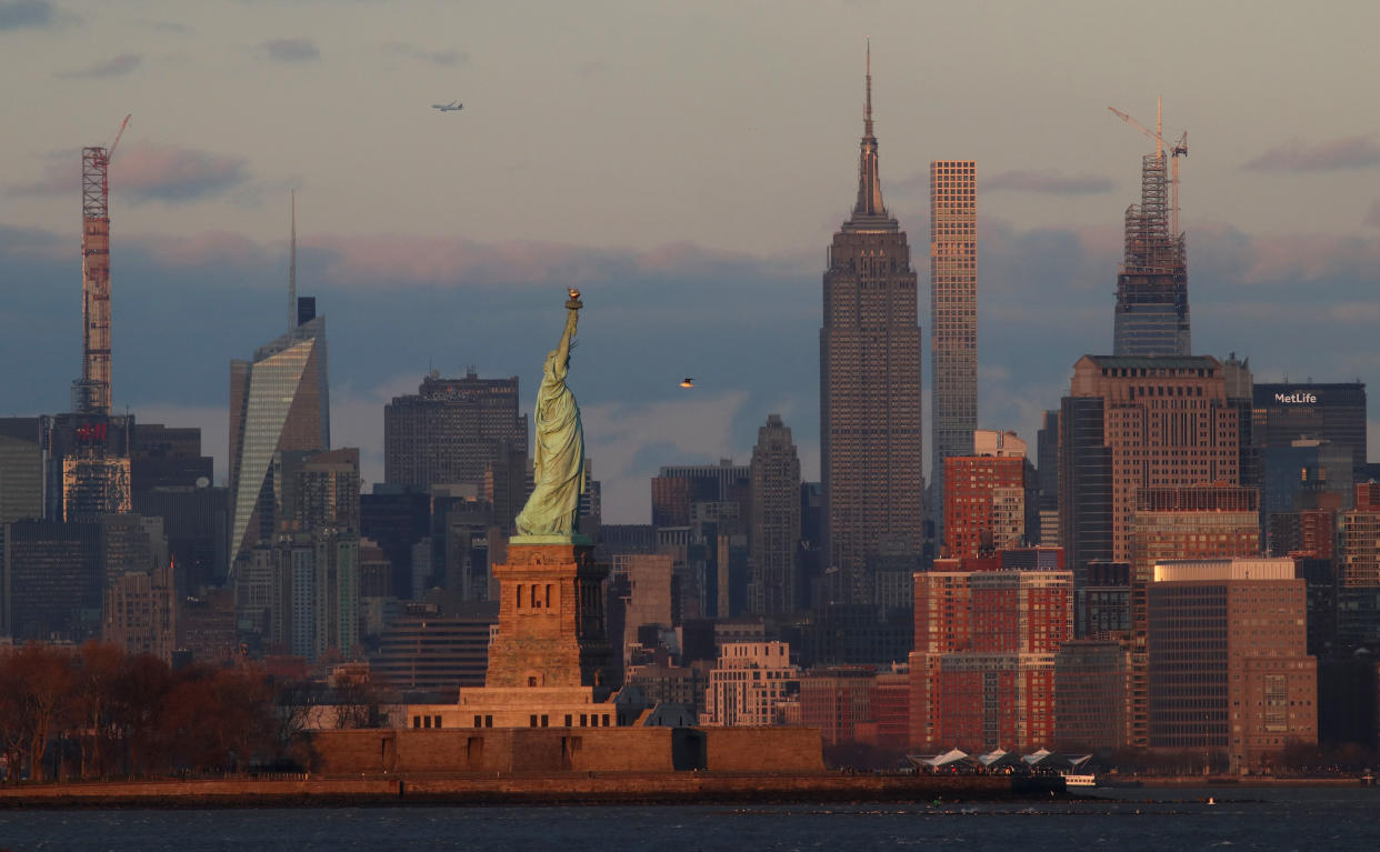 BAYONNE, NJ - DEC 15: The Statue of Liberty stands in front of buildings across midtown Manhattan, the Steinway Tower, Bank of America Building, Rockefeller Center, the Empire State Building, 432 Park Avenue, One Vanderbilt and the MetLife Building as the sun sets in New York City on December 15, 2019 as seen from Bayonne, New Jersey. (Photo by Gary Hershorn/Getty Images)