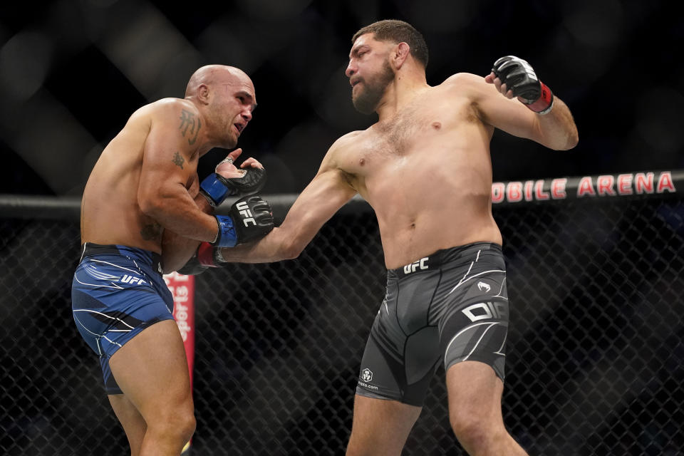 Nick Diaz, right, throws a body punch against Robbie Lawler during a middleweight mixed martial arts bout at UFC 266, Saturday, Sept. 25, 2021, in Las Vegas. (AP Photo/John Locher)