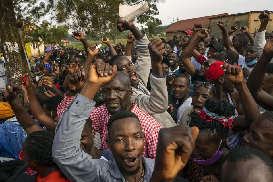 Supporters of leading opposition challenger Bobi Wine cheer as election officials count the ballots after polls closed in Kampala, Uganda, Thursday, Jan. 14, 2021. Ugandans voted in a presidential election tainted by widespread violence that some fear could escalate as security forces try to stop supporters of Wine from monitoring polling stations.(AP Photo/Jerome Delay)