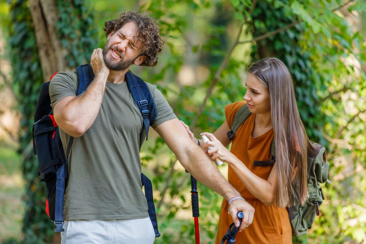 man and his wife are scratching itchy skin due to the attack of insects in nature