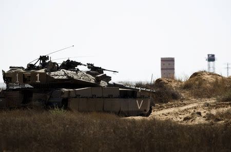 An Israeli army tank takes position along Israel's border with Egypt's North Sinai (seen in background) July 1, 2015. REUTERS/Amir Cohen