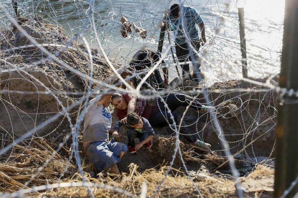 A family desperately burrows through razor wire in an effort to cross the U.S.-Mexico border along the Rio Grande in Eagle Pass, Texas in January.