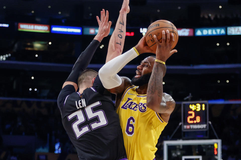 Los Angeles Lakers forward LeBron James (6) is defended by Sacramento Kings center Alex Len (25) during the first half of an NBA basketball game in Los Angeles, Friday, Nov. 26, 2021. (AP Photo/Ringo H.W. Chiu)