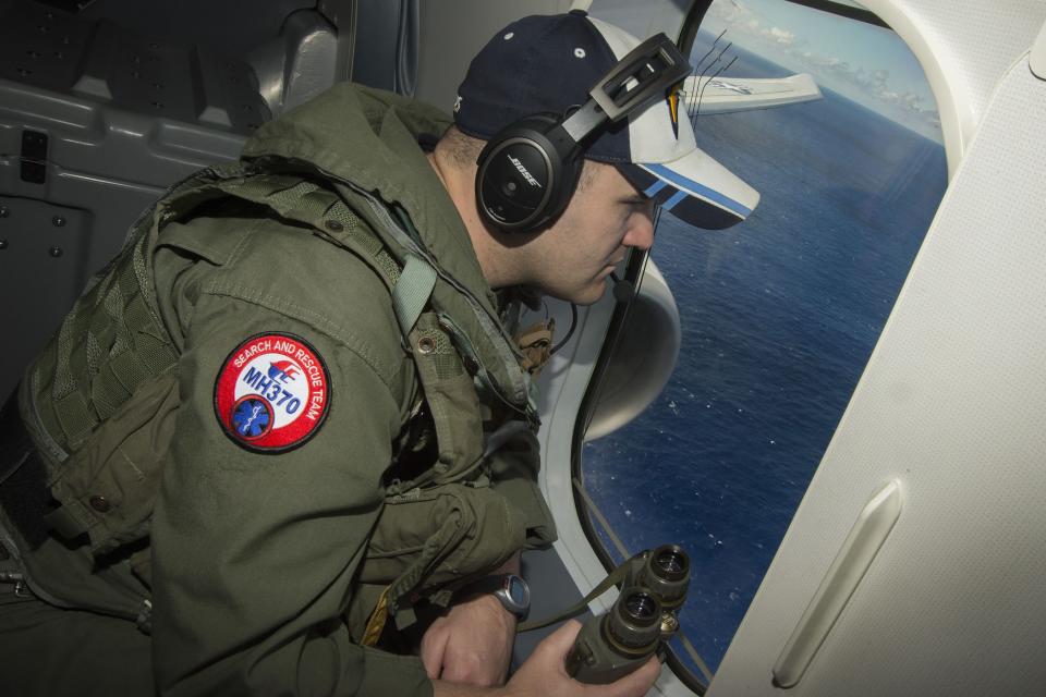 Naval Aircrewman 2nd Class Karl Shinn looks out a window of the US Navy's P-8A Poseidon while flying over the Indian Ocean during a search mission to locate Malaysia Airlines flight MH370. – Reuters pic, April 12, 2014.