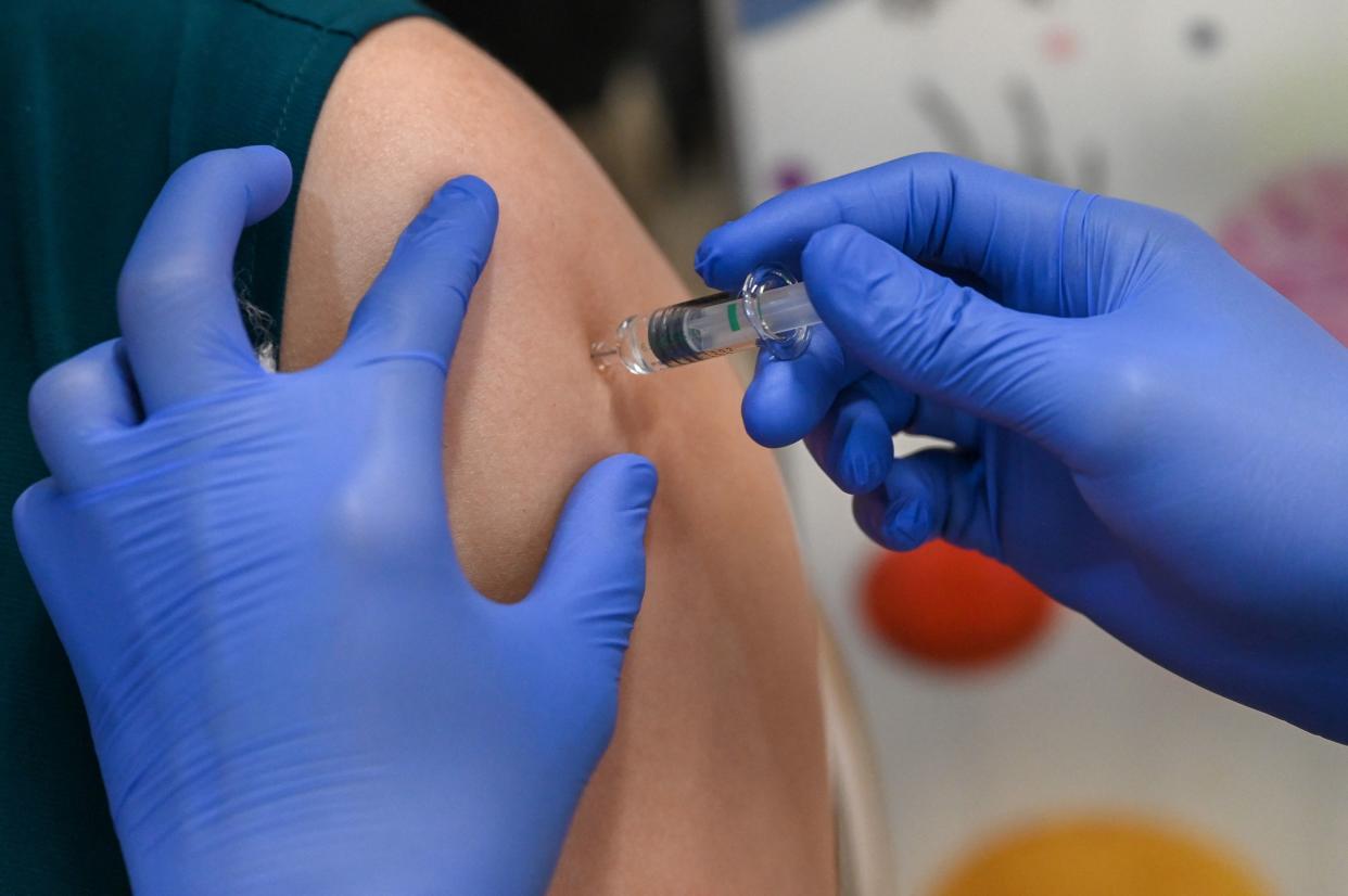 A woman receives a dose of the COVID-19 vaccine at the Mount Elizabeth hospital vaccine centre. 