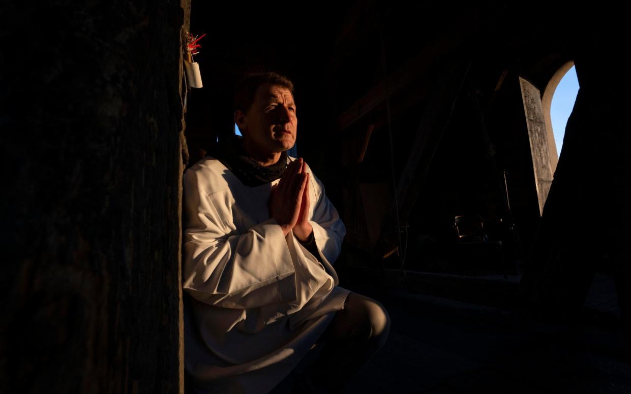 Volodymyr Ilnytskyi, 55, a retired policeman, prays before ringing the bell of the Latin Cathedral in Lviv - AP Photo/Nariman El-Mofty