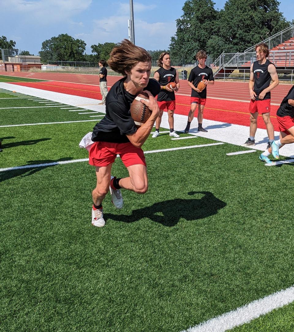 Foothill senior quarterback Hunter Marcione runs with the football tucked in his chest during a practice on Thursday, May 25, 2023.