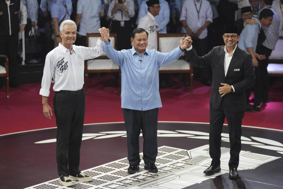 FILE - Presidential candidates, from left, Ganjar Pranowo, Prabowo Subianto and Anies Baswedan hold hands as they pose for photographers after the first presidential candidates' debate in Jakarta, Indonesia, Tuesday, Dec. 12, 2023. The camps of the two presidential candidates who appear to have lost in Indonesia's election last month said Thursday they plan to challenge the results in the Constitutional Court with allegations of widespread fraud. (AP Photo/Tatan Syuflana, File)