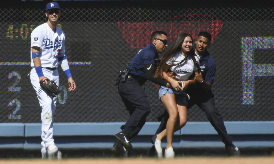 Jun 23, 2019; Los Angeles, CA, USA; Security officers restrain a woman that ran onto the field to Los Angeles Dodgers right fielder Cody Bellinger (35) during the ninth inning at Dodger Stadium. Mandatory Credit: Robert Hanashiro-USA TODAY Sports