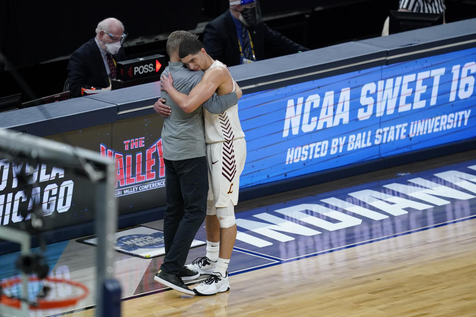 Loyola Chicago head coach Porter Moser, left, hugs guard Lucas Williamson after a Sweet 16 game against Oregon State in the NCAA men's college basketball tournament at Bankers Life Fieldhouse, Saturday, March 27, 2021, in Indianapolis. Oregon State won 65-58. (AP Photo/Darron Cummings)