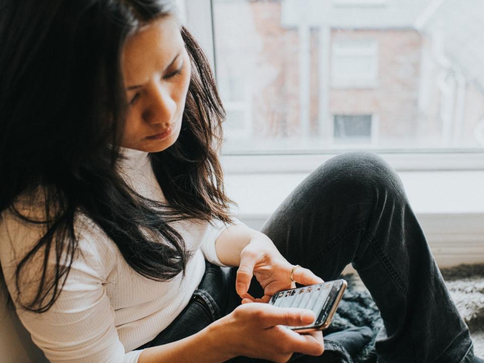 woman looking at phone, sad