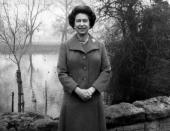 <p>The Queen stands in the gardens of Buckingham Palace to record her 1975 Christmas broadcast. This was the first time she had made her address outdoors. (PA Archive) </p>
