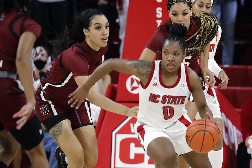 North Carolina State's Diamond Johnson (0) takes a rebound around South Carolina's Brea Beal, left, and Victaria Saxton (5) during the second half of an NCAA college basketball game Tuesday, Nov. 9, 2021, in Raleigh, N.C. (AP Photo/Karl B. DeBlaker)