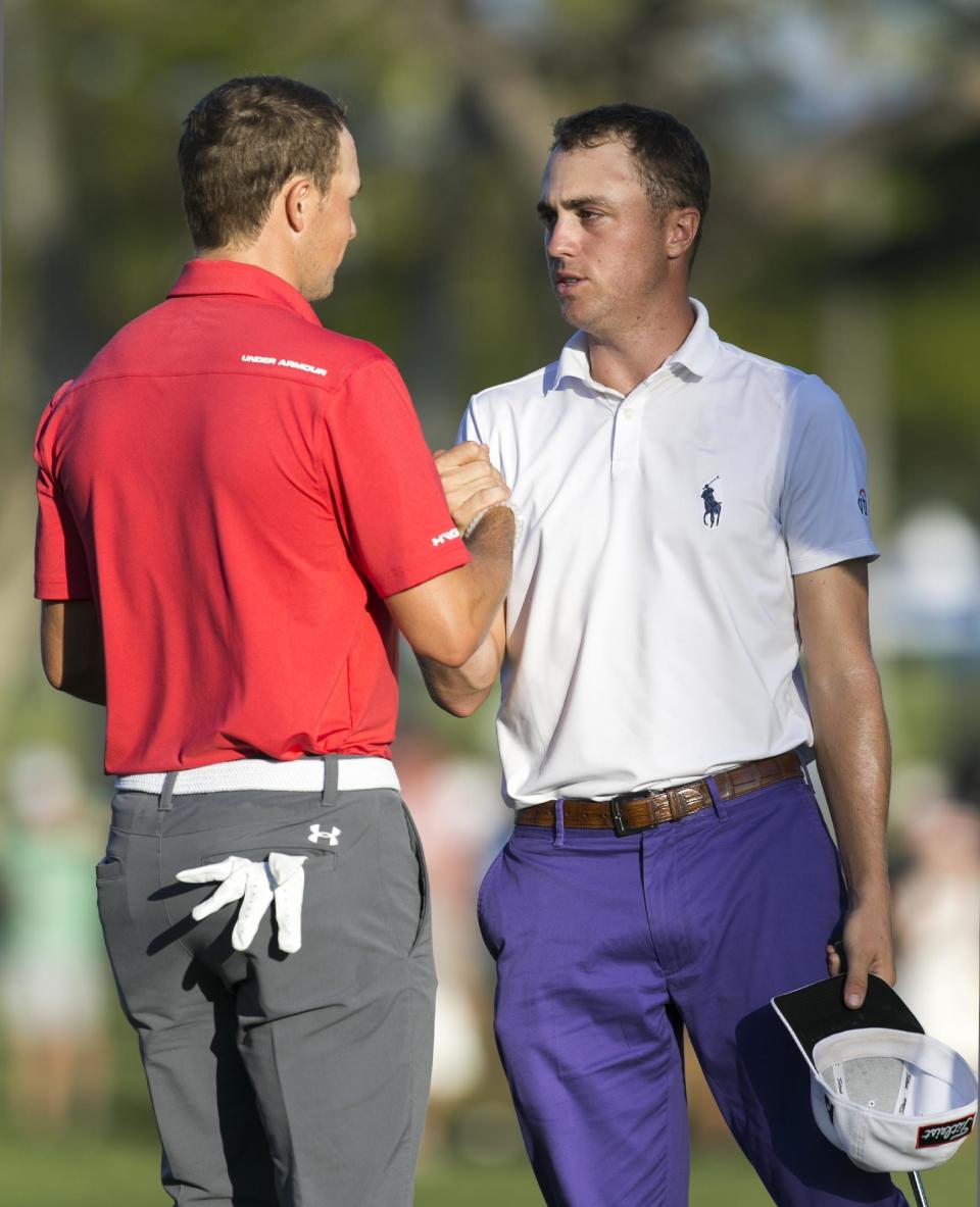 Jordan Spieth, right, shakes hands with Justin Thomas on the 18th green after finishing the second round at the Sony Open golf tournament, Friday, Jan. 13, 2017, in Honolulu. (AP Photo/Marco Garcia)