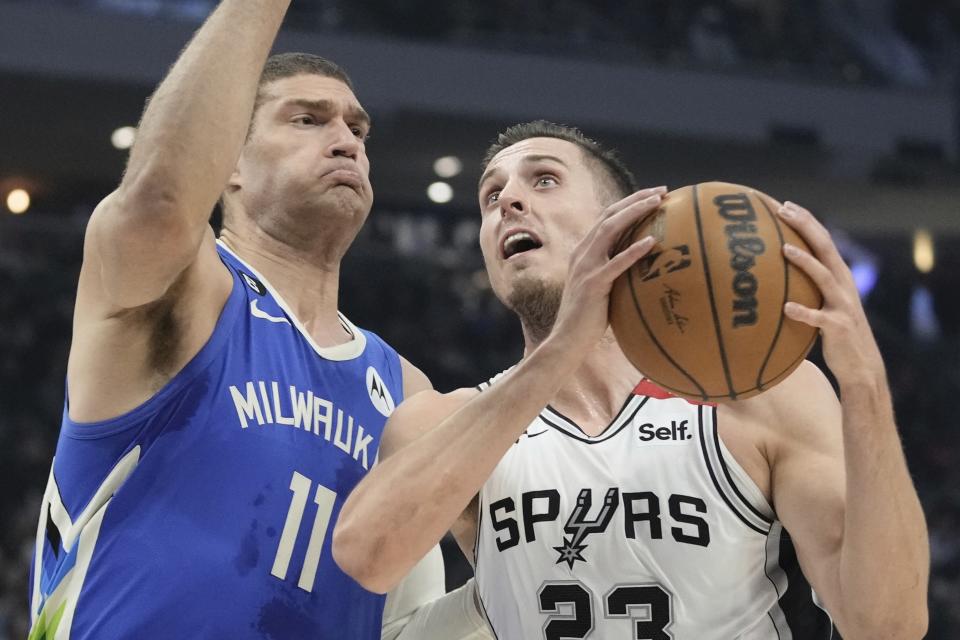 San Antonio Spurs' Zach Collins shoots past Milwaukee Bucks' Brook Lopez during the first half of an NBA basketball game Wednesday, March 22, 2023, in Milwaukee. (AP Photo/Morry Gash)