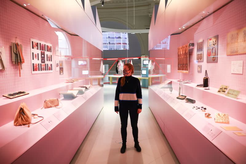 A museum employee poses next to a display of handbags that form part of the 'Bags: Inside Out' exhibition at the Victoria and Albert Museum in London