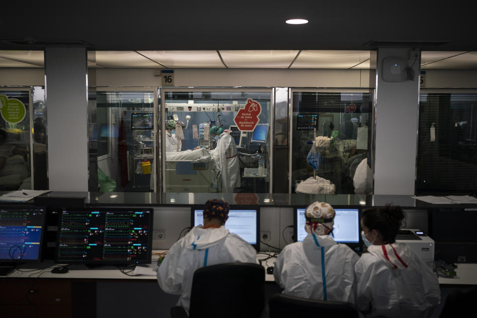 In this Jan. 19, 2021 file photo, COVID-19 patients receive treatment in the ICU of the Hospital del Mar, in Barcelona, Spain. The unrelenting increase in COVID-19 infections in Spain following the holiday season is again straining hospitals, threatening the mental health of doctors and nurses who have been at the forefront of the pandemic for nearly a year. (AP Photo/Felipe Dana)