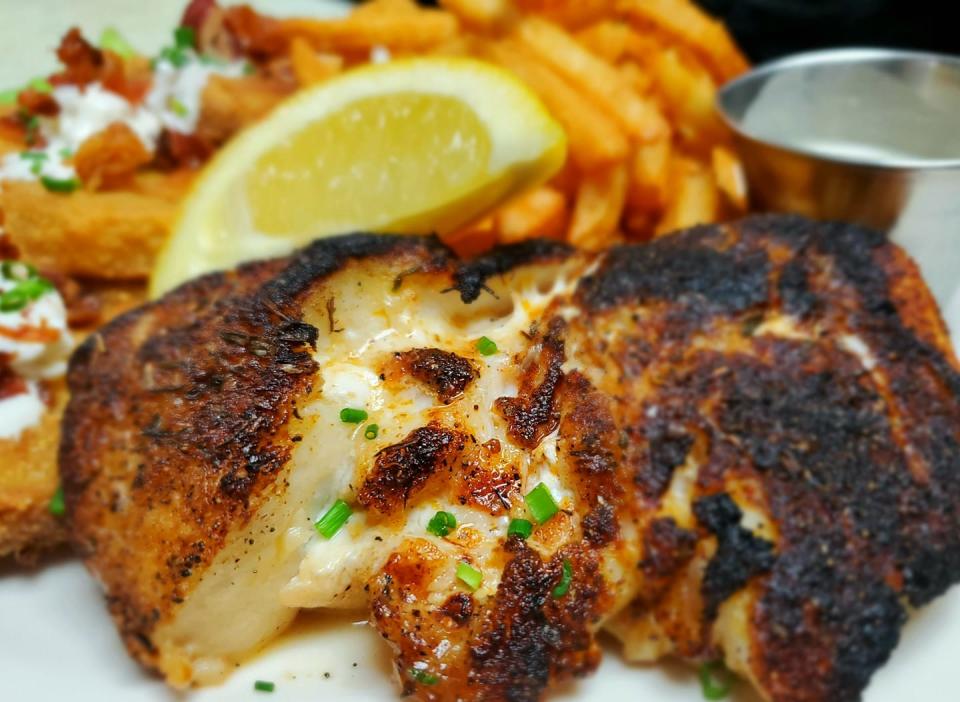 Blackened Gulf Grouper with side of fried green tomatoes and Old Bay fries at Owen's Fish Camp in Sarasota.