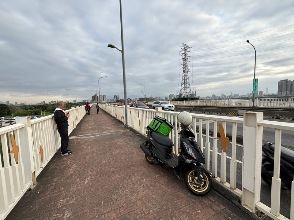 婦人騎乘的外送車就停在橋上。翻攝台北市消防局臉書