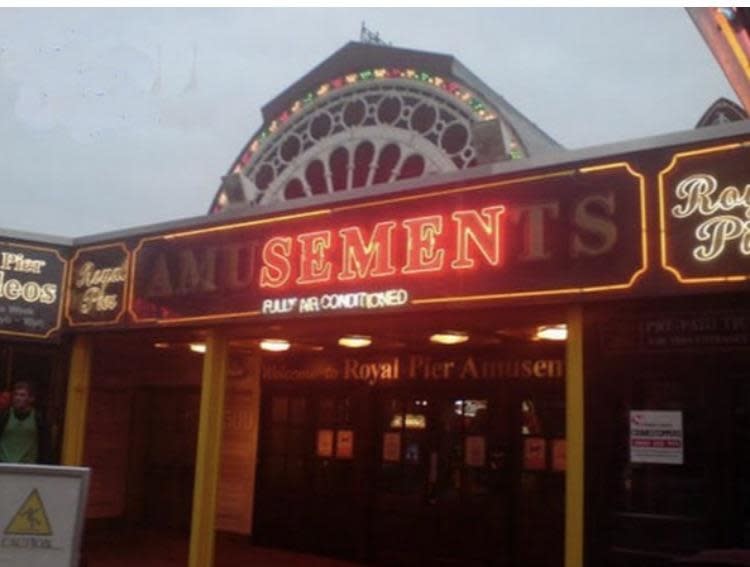 Neon sign reads 'Amusements' above an arcade entrance with only "semen" illuminated