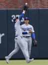 Los Angeles Dodgers center fielder Cody Bellinger catches a fly ball hit by Atlanta Braves' Ronald Acuña Jr., in front of right fielder Trayce Thompson during the first inning of a baseball game Saturday, June 25, 2022, in Atlanta. (AP Photo/Bob Andres)