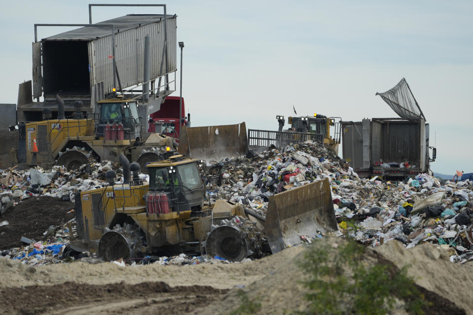 Heavy machinery is used to process trash at the Otay Landfill in Chula Vista, Calif., on Friday, Jan. 26, 2024. Two years after California launched an effort to keep organic waste out of landfills, the state is so far behind on getting food recycling programs up and running that it's widely accepted next year's ambitious waste-reduction targets won't be met. (AP Photo/Damian Dovarganes)