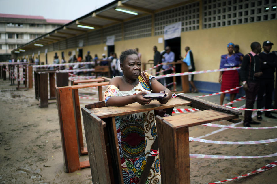 Congolese voters wait at the St. Raphael school in the Limete district of Kinshasa Sunday, Dec. 30, 2018, for voter's listings that have not arrived. People had started to gather at 6am to cast their votes, and four hours later, vote had not started as the lists were not available. Forty million voters are registered for a presidential race plagued by years of delay and persistent rumors of lack of preparation. (AP Photo/Jerome Delay)