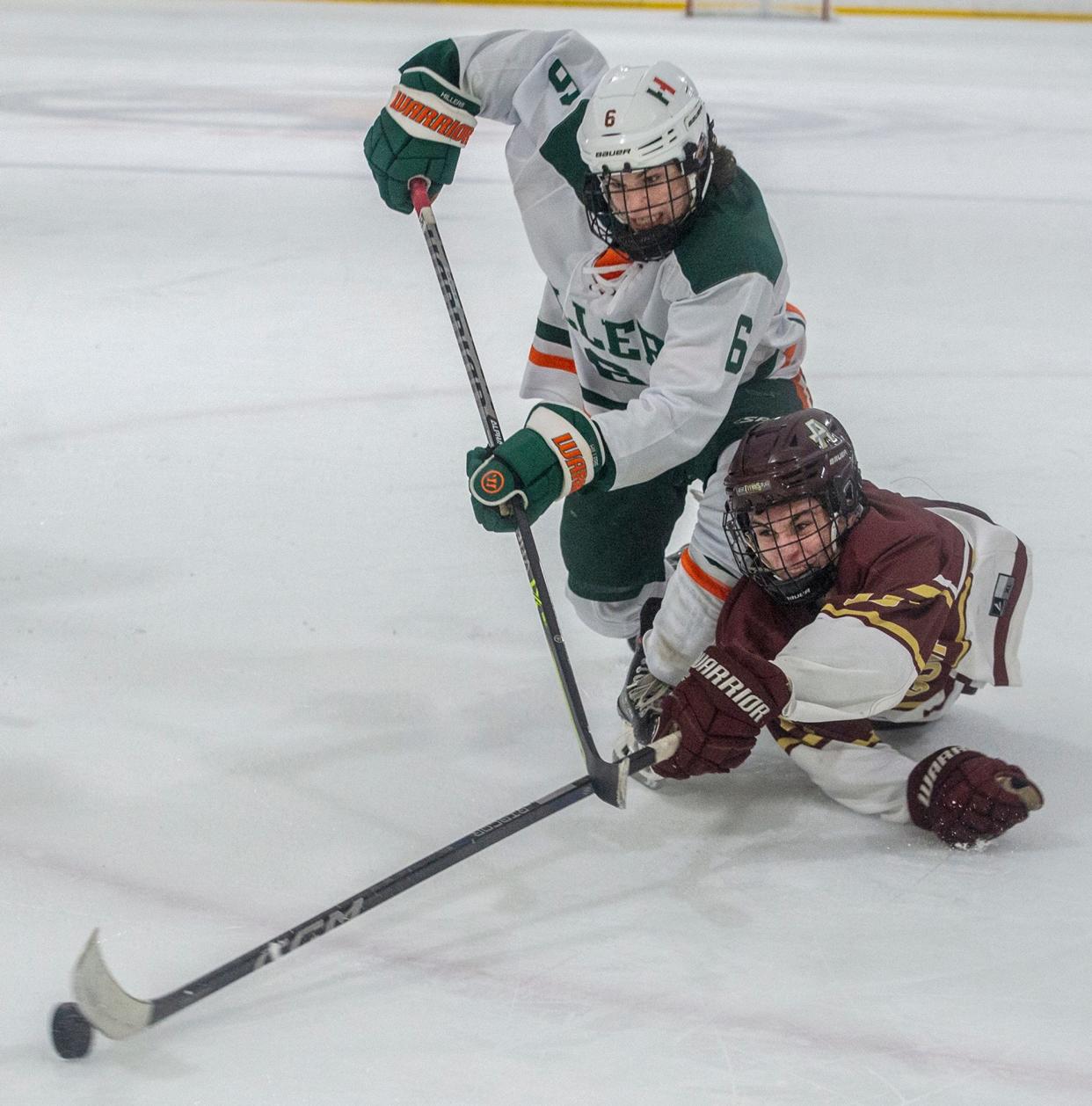 Hopkinton High School's Connor Merkle and an Algonquin's Gilbert Prepetit fight for the puck in the first round of the Daily News Cup at the New England Sports Center, Dec., 27, 2023.
