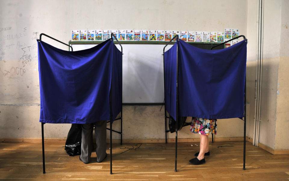 People vote inside booths during the elections in Thessaloniki, Greece, Sunday, June 17, 2012. Greeks voted Sunday for the second time in six weeks in what was arguably their country's most critical election in 40 years, with the country's treasured place within the European Union's joint currency in the balance. (AP Photo/Nikolas Giakoumidis)