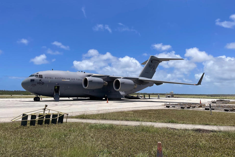 In this photo provided by the Australian Defence Force, a Royal Australian Air Force C-17A Globemaster III aircraft is parked at Fua'amotu International Airport near Nukuʻalofa, Tonga, Thursday, Jan. 20, 2022. The first flights carrying fresh water and other aid to Tonga were finally able to land after the Pacific nation's main airport runway was cleared of ash left by a huge volcanic eruption. (Australian Defence Force via AP)