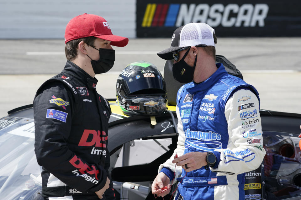 Cousins Harrison Burton, left, and Jeb Burton talk prior to the start of the rain delayed NASCAR Xfinity Series auto race at Martinsville Speedway in Martinsville, Va., Sunday, April 11, 2021. (AP Photo/Steve Helber)