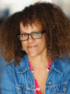 Novelist Bernardine Evaristo wearing a denim jacket and glasses