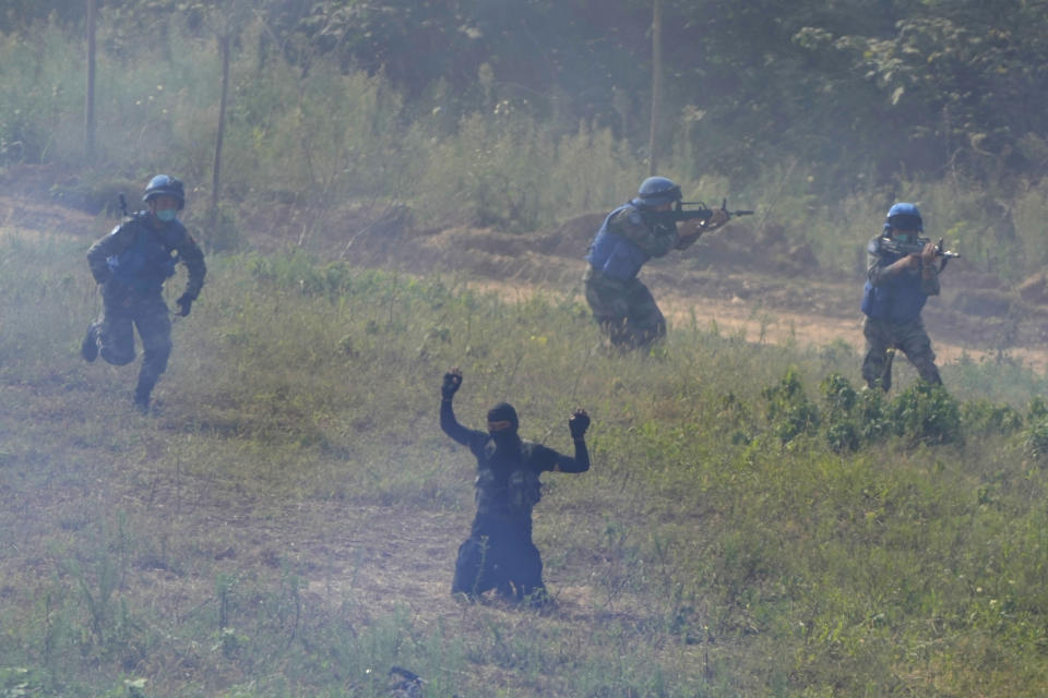 A participant playing the role of a terrorist surrenders after a failed attack on a United Nations base during the Shared Destiny 2021 drill at the Queshan Peacekeeping Operation training base in Queshan County in central China's Henan province Wednesday, Sept. 15, 2021. Peacekeeping troops from China, Thailand, Mongolia and Pakistan took part in the 10 days long exercise that field reconnaissance, armed escort, response to terrorist attacks, medical evacuation and epidemic control. (AP Photo/Ng Han Guan)