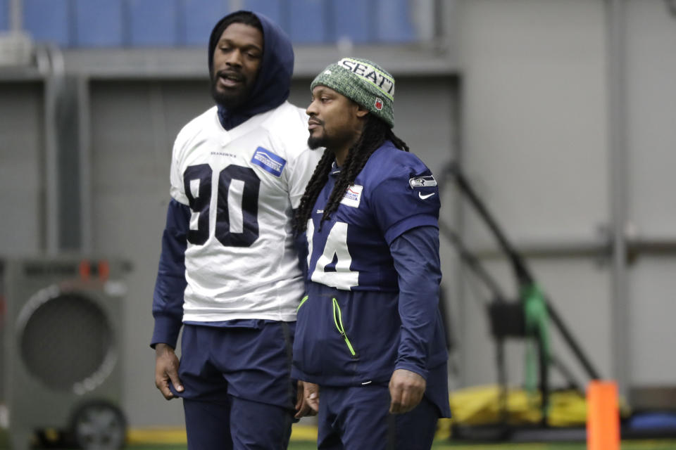 Seattle Seahawks running back Marshawn Lynch, right, talks with defensive end Jadeveon Clowney, left, before NFL football practice, Friday, Dec. 27, 2019, in Renton, Wash. (AP Photo/Ted S. Warren)