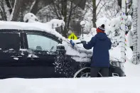 A person clears snow off their car after a winter storm rolled through Western New York Tuesday, Dec. 27, 2022, in Amherst, N.Y. (AP Photo/Jeffrey T. Barnes)