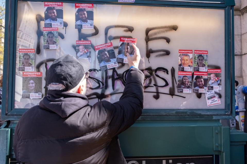 A counter protester put up images of the Hamas hostages over a sign that read, “Free Palestine.” DANIEL WILLIAM MCKNIGHT