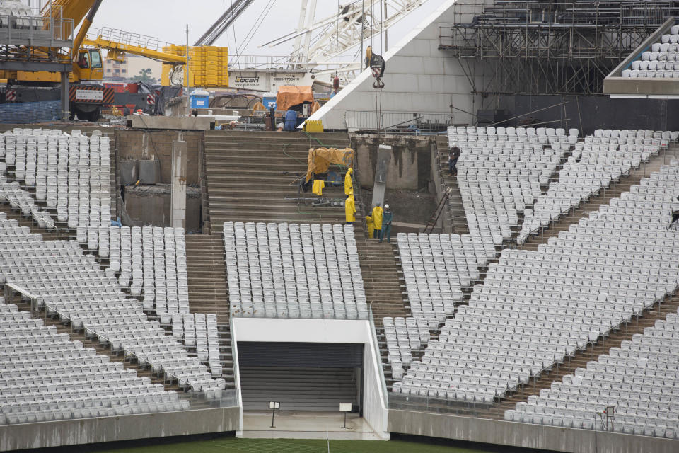 Men work at the still unfinished Itaquerao stadium in Sao Paulo, Brazil, Tuesday, April 15, 2014. The stadium that will host the World Cup opener match between Brazil and Croatia on June 12, will hold nearly 70,000 people in the opener, but after the World Cup its capacity will be reduced to about 45,000. (AP Photo/Andre Penner)