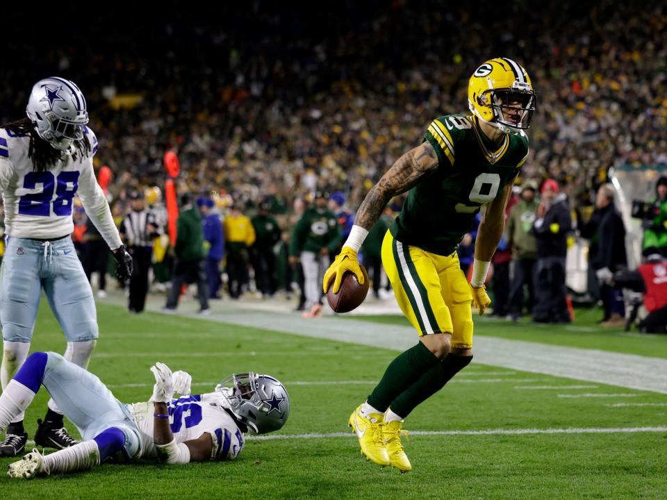 Christian Watson celebrates a touchdown against the Dallas Cowboys.