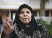 A woman holds up her ink-stained finger after casting her ballot in a municipal election in Benghazi April 19, 2014. REUTERS/Esam Omran Al-Fetori