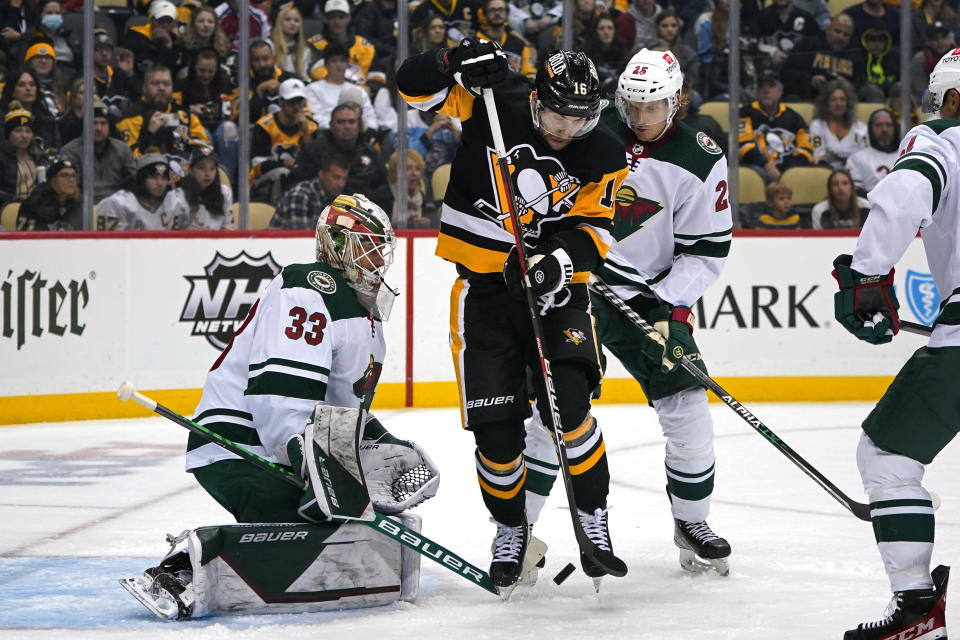 Pittsburgh Penguins' Jason Zucker (16) can't get his stick on a rebound in front of Minnesota Wild goaltender Cam Talbot (33) with Andrew Hammond (35) defending during the second period of an NHL hockey game in Pittsburgh, Saturday, Nov. 6, 2021. (AP Photo/Gene J. Puskar)