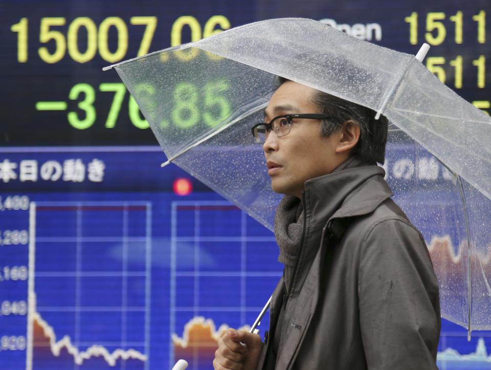 A man walks by an electronic stock board of a securities firm in Tokyo Thursday, Jan. 30, 2014. Shares fell Thursday in Asia as weak economic data from China and Japan deepened concerns over ongoing reductions in U.S. monetary stimulus. Japan's Nikkei 225 index was down 2.6 percent at 14,887.96 after the government reported that retail sales fell 1.1 percent in December from the month before. It gained slightly and closed at 15,007.06 for the day. (AP Photo/Koji Sasahara)