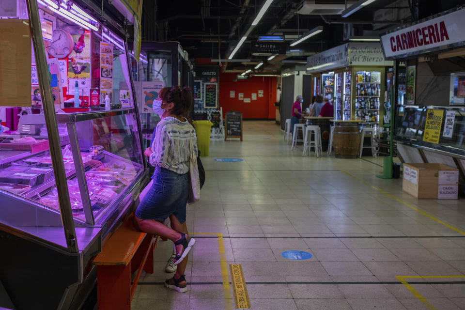 A customer, wearing a face mask to protect against the coronavirus, buys meat at a local market in Madrid, Spain, Tuesday, Sept. 15, 2020. (AP Photo/Bernat Armangue)