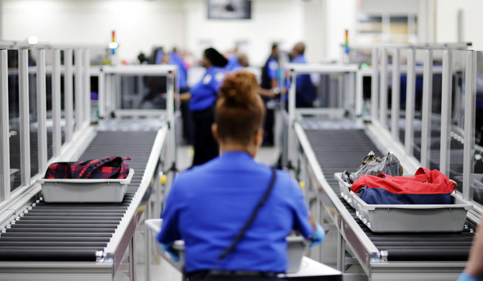 FILE - In this May 25, 2016, file photo, bins containing bags needing additional screening are automatically separated on a conveyer belt at a newly designed passenger screening lane unveiled at Hartsfield-Jackson Atlanta International Airport in Atlanta. A passenger undergoing a search at the Atlanta airport's main security checkpoint reached into a bag and grabbed a firearm, and it went off, causing chaos among travelers and prompting a temporary ground stop on flights Saturday afternoon, Nov. 20, 2021, authorities said. The TSA said the passenger fled out an airport exit. (AP Photo/David Goldman, File)