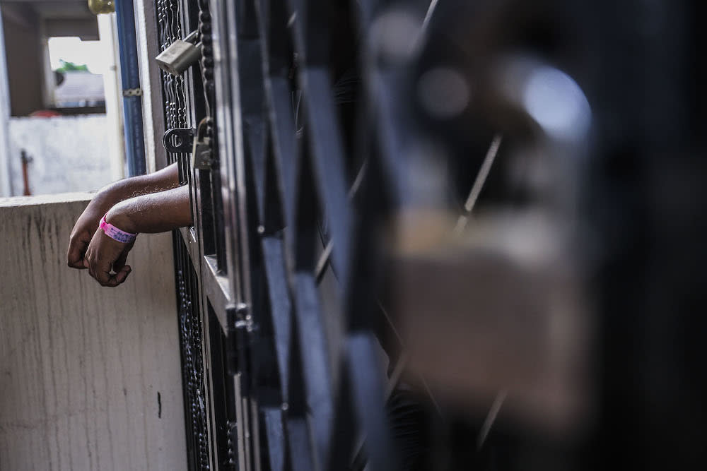 A man is seen standing at his house gate after being ordered to undergo home quarantine in Kuala Lumpur October 4, 2020. — Picture by Hari Anggara.